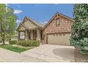 Beautiful single-Gathering home with a two-car garage and brick and siding exterior under a blue sky at 6085 Nile Cir, Golden, CO 80403
