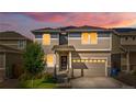 Charming two-story home featuring manicured landscaping and a spacious two-car garage at dusk at 244 Chipeta Way, Lochbuie, CO 80603