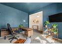 Office space with a wooden desk, office chair, and stylish decor plus a view to an open hallway at 244 Chipeta Way, Lochbuie, CO 80603
