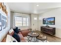 Comfortable living room featuring neutral tones, a large window, and seamless flow to other spaces at 956 Andrews Crest Dr, Berthoud, CO 80513