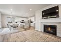 Spacious open-concept living area features a fireplace, a large TV, and seamless flow to the modern kitchen at 11783 Niagara St, Thornton, CO 80233