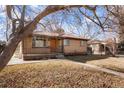 Charming brick home featuring a cozy front porch and mature trees at 2695 S Josephine St, Denver, CO 80210