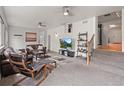 Cozy living room boasts plush seating, a ceiling fan, and decorative shelves on the staircase at 3241 Sheridan Blvd, Wheat Ridge, CO 80212
