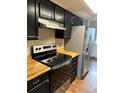Modern kitchen with stainless steel appliances and wood countertops at 8643 Carr Loop, Westminster, CO 80005