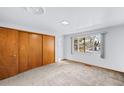 Bright bedroom with neutral carpet, a window with natural light, and a closet at 3131 S Washington St, Englewood, CO 80113