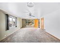 Bright living room with neutral carpet, ceiling fan, and large windows at 3131 S Washington St, Englewood, CO 80113
