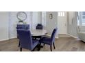 Cozy dining room with modern table and stylish blue upholstered chairs at 24963 E Phillips Pl, Aurora, CO 80016