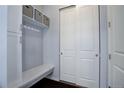 Functional entryway with built-in bench, coat hooks, and storage shelves near closet at 24963 E Phillips Pl, Aurora, CO 80016