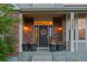 Inviting front porch with brick accents, potted flowers, and a charming entrance. Address 27290 at 27290 E Nova Cir, Aurora, CO 80016