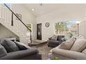 Bright living room with vaulted ceilings, staircase, and comfortable seating arrangement at 11816 Zenobia Loop, Westminster, CO 80031