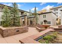 Charming courtyard with stone benches, manicured landscaping, pergola, and tranquil fountain at 2800 Aurora Ave # 118, Boulder, CO 80303