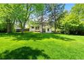 Spacious backyard featuring a lush lawn and mature trees, perfect for outdoor activities and relaxing at 6544 Alkire Ct, Arvada, CO 80004