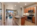 Bright and spacious kitchen with an island, stainless steel appliances, and wood flooring at 14341 E Tennessee Ave # 203, Aurora, CO 80012