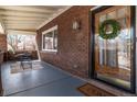 Cozy front porch featuring a seating area, brick accents, and a decorative wreath on the front door at 1601 Jackson St, Denver, CO 80206