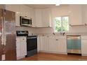Bright kitchen with stainless appliances, white cabinets, and a window view at 1705 Cathay Ct, Aurora, CO 80011