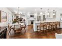 Bright, open-concept kitchen and dining area with hardwood floors and modern fixtures at 5965 S Gaylord Way, Greenwood Village, CO 80121