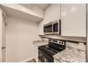 Updated kitchen with stainless steel range and microwave at 2880 S Locust St # 704N, Denver, CO 80222