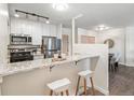 Well-lit kitchen features a breakfast bar, modern stainless steel appliances, and white cabinets at 2880 S Locust St # 704N, Denver, CO 80222