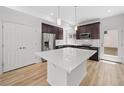 Well-lit kitchen featuring stainless steel appliances, wooden floors, a center island, and dark wood cabinetry at 1199 Highview Dr, Erie, CO 80516