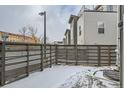 Cozy fenced backyard with light snow coverage near modern residential building at 2804 W 53Rd Ave, Denver, CO 80221