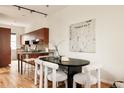 Modern dining area featuring wood cabinets, sleek island, and dining table with stylish white chairs at 2680 Blake St # 12, Denver, CO 80205