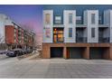 Modern townhouse with a blue and silver facade, brick accents and garage parking at 2680 Blake St # 12, Denver, CO 80205