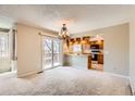 Spacious dining area leading to outdoor deck, with easy access to kitchen featuring wood cabinetry at 1470 S Quebec Way # 46, Denver, CO 80231