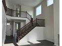 Bright entryway featuring a staircase with dark wood railings, creating a grand and welcoming atmosphere at 16654 W 93Rd Way, Arvada, CO 80007