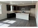 Modern kitchen showcasing dark wood cabinetry, a large island with white countertops, and stainless steel appliances at 16654 W 93Rd Way, Arvada, CO 80007