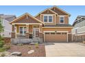 Charming two-story home featuring a covered front porch, stone accents, and a two-car garage at 24416 E Powers Ave, Aurora, CO 80016