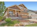 Charming two-story home showcasing a covered front porch, stone accents, and a well-maintained front yard at 24416 E Powers Ave, Aurora, CO 80016