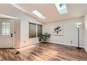 Bright living room with wood floors, skylights, and neutral paint at 8432 S Upham Way, Littleton, CO 80128