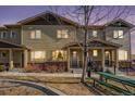 Charming two-story townhome boasting a stone foundation, lush landscaping, and a cozy front porch at 1631 Aspen Meadows Cir, Denver, CO 80260