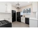 Modern kitchen with white cabinets, black appliances, and patterned tile floors at 319 13Th Ave, Idaho Springs, CO 80452