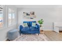 Bright living room with blue couch and wood-look floors at 6000 Krameria St, Commerce City, CO 80022