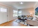 Bright living room with hardwood floors, neutral paint, and a view of the front yard at 1969 Uinta St, Denver, CO 80220