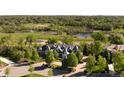 Stunning aerial view of a luxury home with a lake view surrounded by lush greenery and a picturesque neighborhood at 5470 S Highline Cir, Greenwood Village, CO 80121