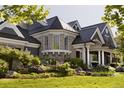 An elegant home with stone accents, manicured landscaping, and a turret-style window adds curb appeal at 5470 S Highline Cir, Greenwood Village, CO 80121