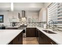 Modern kitchen features stainless steel appliances, dark wood cabinets, white countertops, and stylish backsplash at 2622 W 24Th Ave # 2, Denver, CO 80211