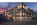 Stunning brick condo building with balconies and modern architectural details against a dramatic sunset sky at 1489 Steele St # 104, Denver, CO 80206