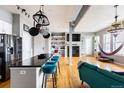 Open-concept living space with kitchen island, fireplace, hardwood floors, and bright natural light at 1489 Steele St # 104, Denver, CO 80206