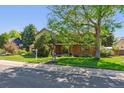 Charming two-story home with landscaped yard and mature shade trees on a sunny day at 5755 S Fulton Way, Greenwood Village, CO 80111
