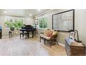 Sun-filled living room showcasing hardwood floors, a piano, and a comfortable seating area at 5755 S Fulton Way, Greenwood Village, CO 80111