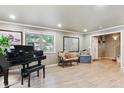 Bright living room features hardwood floors, piano, large windows, and elegant decor at 5755 S Fulton Way, Greenwood Village, CO 80111