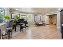 Bright living room featuring hardwood floors, large windows, and a grand piano at 5755 S Fulton Way, Greenwood Village, CO 80111