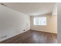 A bright living room with sleek hard surface flooring and a large picture window at 13393 E Louisiana Ave, Aurora, CO 80012