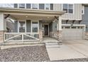Inviting front porch showcasing stone accents, a neutral color scheme, and a well-manicured lawn at 935 Peach Leaf Ln, Elizabeth, CO 80107
