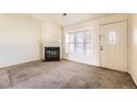 Cozy living room with a fireplace, carpeted floors and ample natural light from a window at 1100 S Waco St # D, Aurora, CO 80017