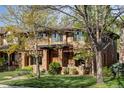 Beautiful two-story brick home with a covered porch, manicured lawn and mature trees at 1143 S Saint Paul St, Denver, CO 80210