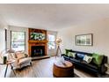 Cozy living room featuring a beautiful fireplace and plenty of natural light from large windows at 4621 S Fraser Cir # A, Aurora, CO 80015